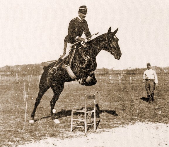 Italian_School_-Federico_Caprilli_jumping_a_chair(bw_photo)-(MeisterDrucke-1458595)